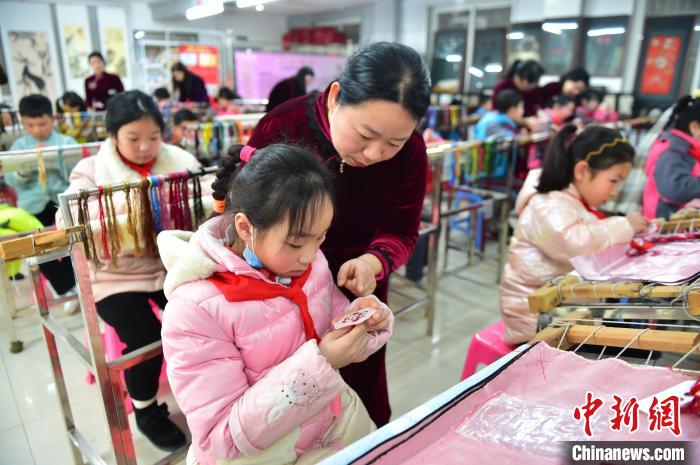 江西省級非遺豫章繡傳承人手把手指導小學生繡制2022年北京冬奧會吉祥物“冰墩墩”形象?！∮髟屏?攝