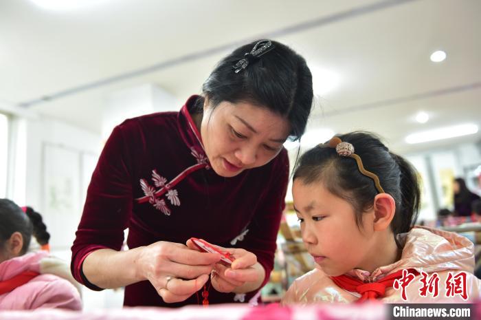 江西省級非遺豫章繡傳承人手把手指導小學生繡制2022年北京冬奧會吉祥物“冰墩墩”形象?！∮髟屏?攝