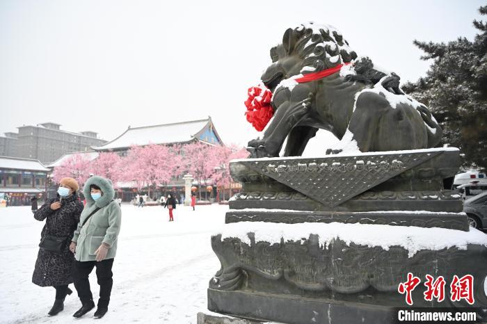 2月13日，民眾在呼和浩特市大召廣場雪中漫步?！⑽娜A 攝