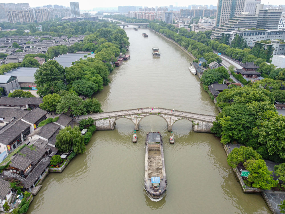 5月27日，一艘貨船駛過京杭大運(yùn)河南端標(biāo)志建筑杭州拱宸橋。(無人機(jī)照片)新華社記者江漢 攝
