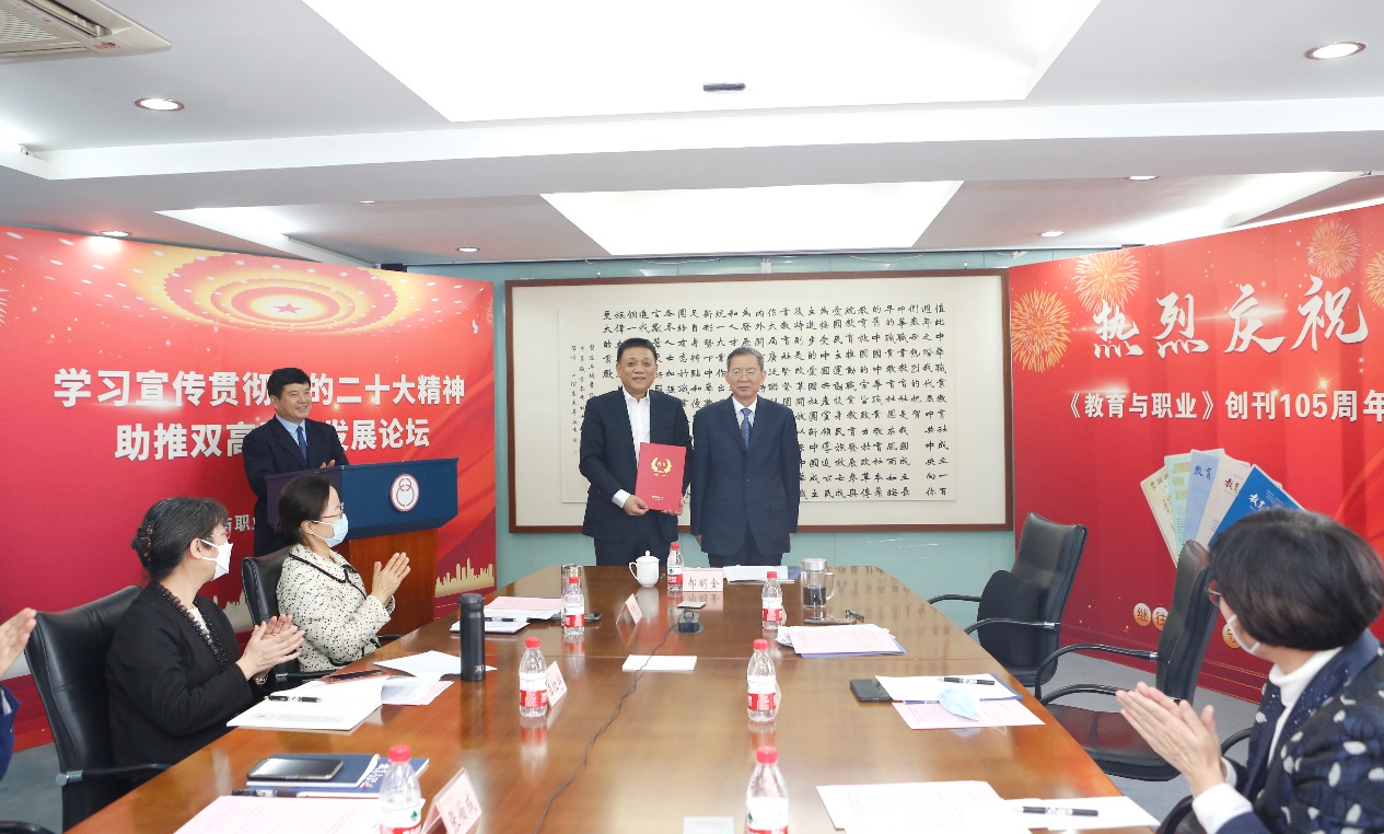 郝明金為《教育與職業(yè)》雜志編委代表陳曉明頒發(fā)聘書。中華職教社供圖