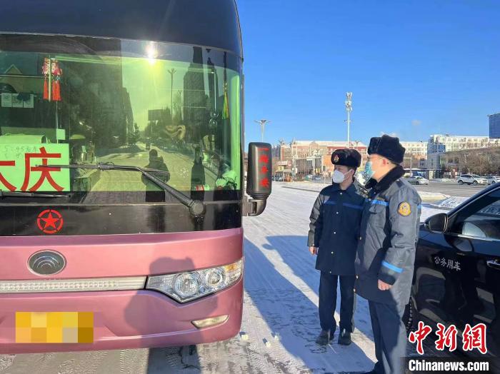 交通執(zhí)法人員檢查客運車輛手續(xù)。　黑龍江省交通運輸廳供圖