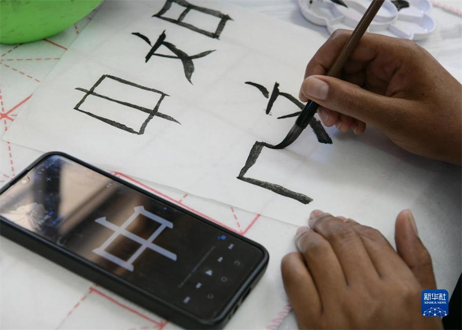 4月18日，肯尼亞學(xué)生在內(nèi)羅畢大學(xué)孔子學(xué)院舉辦的活動上寫毛筆字。肯尼亞內(nèi)羅畢大學(xué)孔子學(xué)院18日舉辦“中文，增進(jìn)文明對話”主題活動，慶祝即將到來的第14個聯(lián)合國中文日?？夏醽唽W(xué)生參與互動，進(jìn)行書法、剪紙、唱中文歌等活動。新華社記者 韓旭 攝