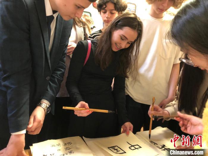 4月21日，莫斯科國立語言大學(xué)孔子學(xué)院附屬中學(xué)舉辦“國際中文日”活動，學(xué)生們學(xué)寫漢字?！∧箍茋⒄Z言大學(xué)孔子學(xué)院 供圖