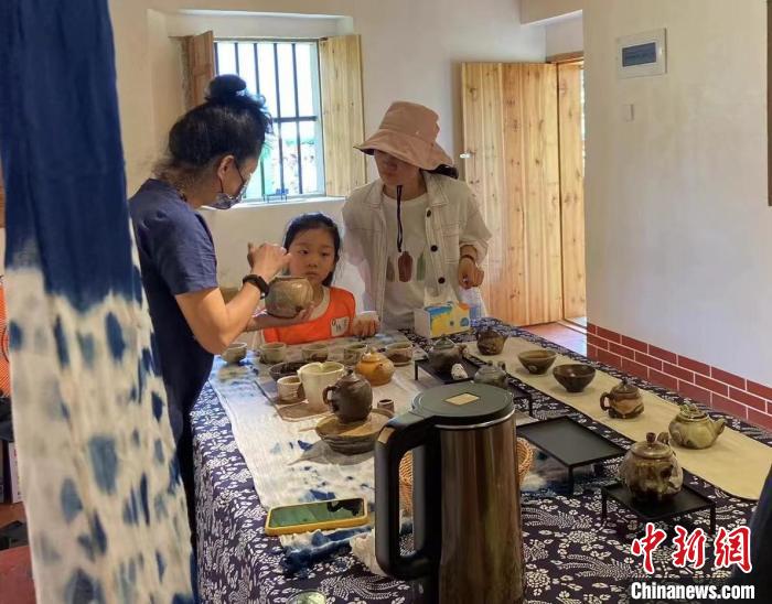 圖為：游客正在咨詢臺灣柴燒作品?！∪~秋云 攝