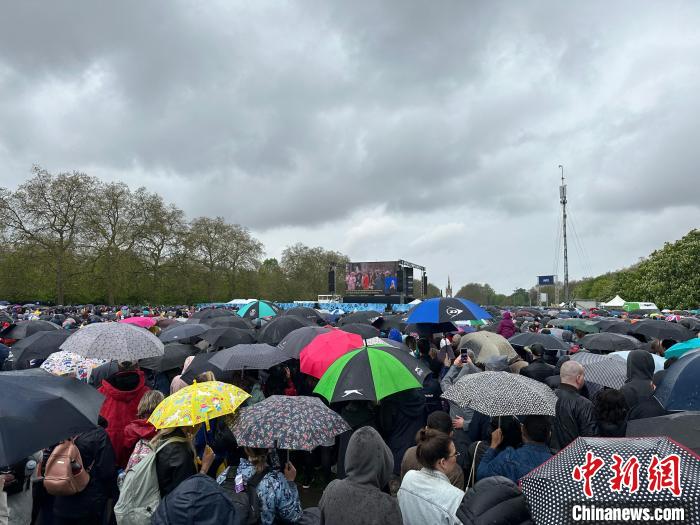 當(dāng)?shù)貢r間5月6日，英國國王查爾斯三世的加冕儀式舉行。民眾雨中觀看儀式。　歐陽開宇 攝