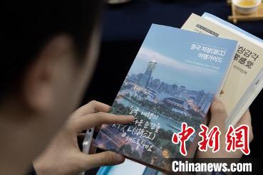 參展觀眾閱讀浙江文旅手冊?！《≌裾?攝