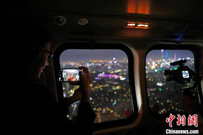 6月3日晚，游客乘坐上海新空直升機有限公司直升機開啟鳥瞰黃浦江空中圓夢之旅，并用手機拍攝城市夜景?！∫罅⑶?攝
