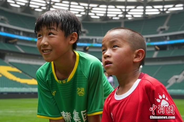 圖為北京國安小球員陳小北和7歲的俄金仁增在一起觀看場內(nèi)播放的紀(jì)錄片。<a target='_blank' href='/' _fcksavedurl='/'><p  align=
