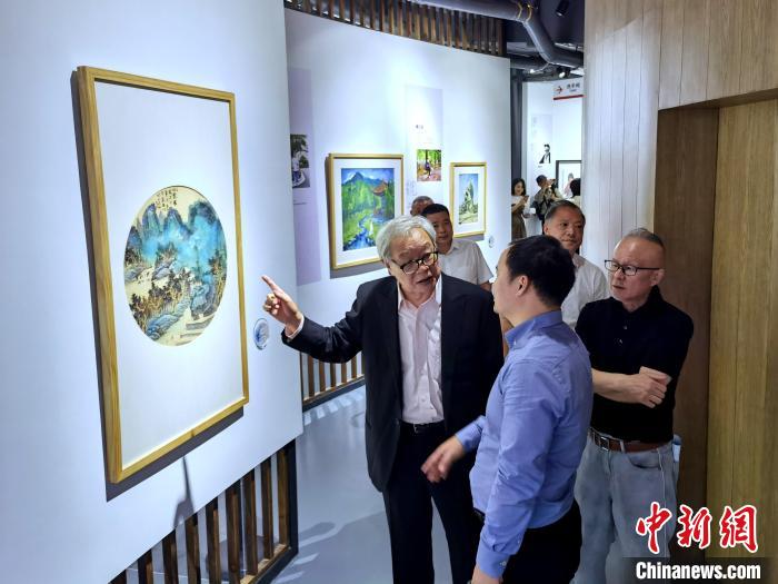 海峽兩岸藝術(shù)家畫展上，藝術(shù)家進(jìn)行藝術(shù)交流?！「毒窜?攝