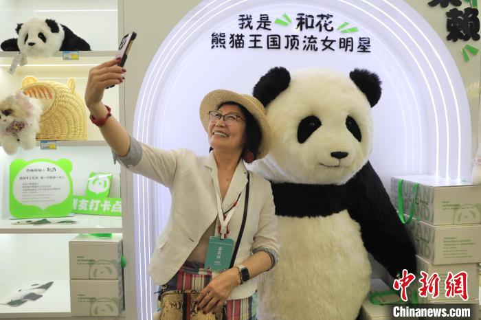 美國華視總裁楊蓮花與大熊貓文創(chuàng)產(chǎn)品合影?！⊥趵?攝