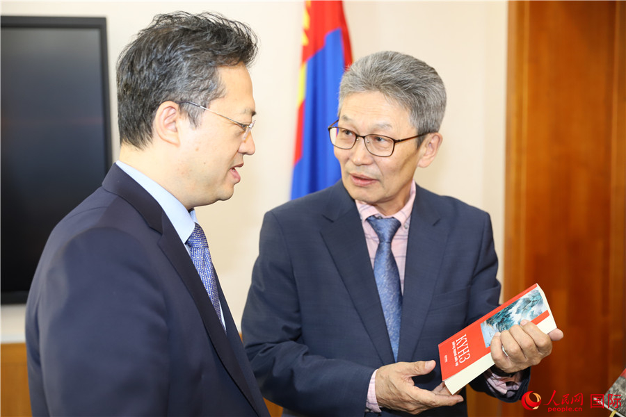 其米德策耶（右一）向李峙介紹翻譯成果。人民網(wǎng)記者 霍文攝