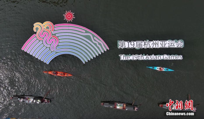 資料圖為烏篷船和皮劃艇從杭州亞運會標識前劃過。王剛 攝