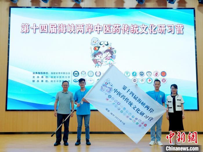 共青團福建省委副書記吳雪(右一)、福建中醫(yī)藥大學黨委副書記林羽(左一)為兩岸學生代表頒授營旗。　許燁婷 攝