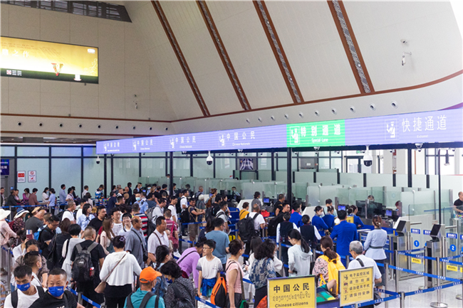 7月22日，乘坐中老鐵路國際旅客列車的旅客在磨憨邊檢大廳排隊(duì)候檢。衛(wèi)海林 攝