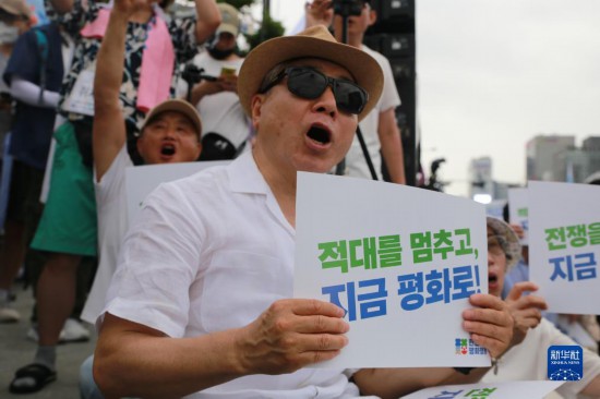 7月22日，在韓國首爾，人們手舉標(biāo)語參與反戰(zhàn)游行。新華社發(fā)（楊暢 攝）