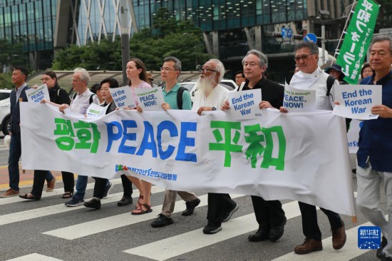 7月22日，在韓國首爾，人們手舉標(biāo)語參與反戰(zhàn)游行。新華社發(fā)（楊暢 攝）