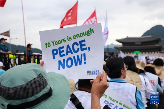7月22日，在韓國首爾，人們手舉標(biāo)語參與反戰(zhàn)游行。新華社發(fā)（楊暢 攝）
