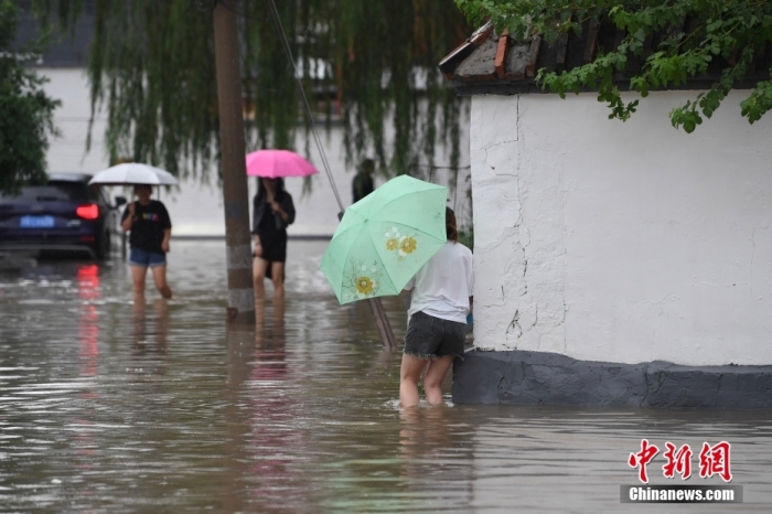 7月31日，市民行走在雨中的北京房山區(qū)瓦窯頭村。北京市氣象臺當日10時發(fā)布分區(qū)域暴雨紅色預警信號。北京市水文總站發(fā)布洪水紅色預警，預計當日12時至14時，房山區(qū)大石河流域?qū)⒊霈F(xiàn)紅色預警標準洪水。<a target='_blank' href='/'><p  align=