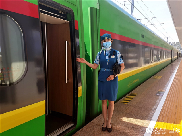 趙瑩靜站在“復(fù)興號(hào)”國(guó)際旅客列車車廂門口歡迎旅客上車。人民網(wǎng) 杜明明攝