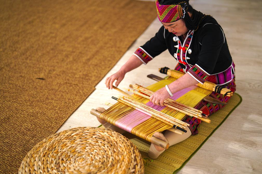 4月17日，黎族傳統(tǒng)紡染織繡技藝國(guó)家級(jí)代表性傳承人劉香蘭在2023年意大利米蘭設(shè)計(jì)周上展示黎錦織造技藝。新華社發(fā)