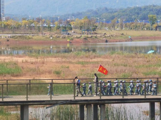 　　10月24日，秋游的幼兒園小朋友在老師帶領(lǐng)下走在清水塘公園里的木橋上。本報記者 常雯宜攝