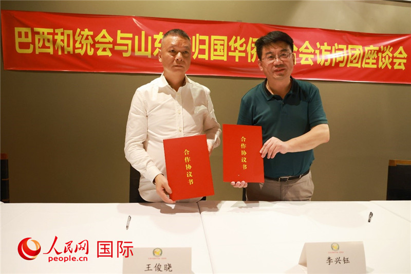 中國(guó)僑聯(lián)副主席、山東省僑聯(lián)主席李興鈺（右）與巴西和統(tǒng)會(huì)會(huì)長(zhǎng)王俊曉簽署合作協(xié)議書(shū)。人民網(wǎng)記者 陳海琪攝