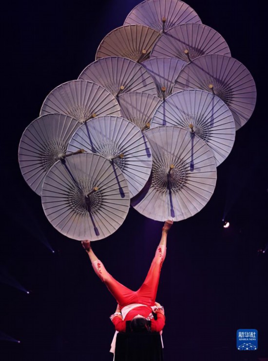 12月8日，演員在法國(guó)巴黎舉行的中國(guó)雜技“奇妙之夜”演出上表演《蹬傘》。新華社記者 高靜 攝