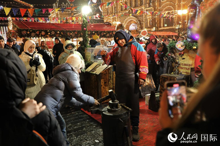 游客在新年集市上體驗制作紀念幣。人民網(wǎng)記者 隋鑫攝