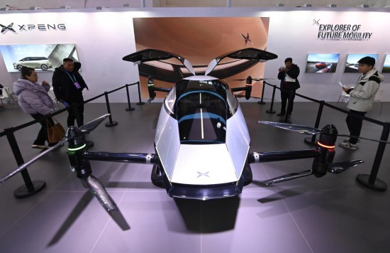 2023年12月1日，在鏈博會智能汽車鏈展區(qū)小鵬汽車展臺，參觀者觀看一臺智能飛行器。新華社記者蔡湘鑫攝