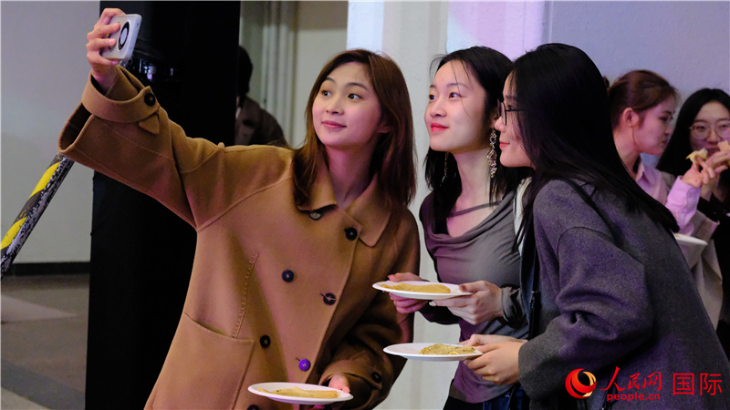 中國觀眾在現(xiàn)場品嘗“謝肉節(jié)”節(jié)日美食——煎薄餅。人民網(wǎng) 褚夢琦攝