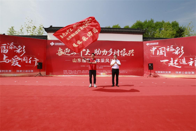 為媒體采風(fēng)團(tuán)授旗。 山東省福彩供圖