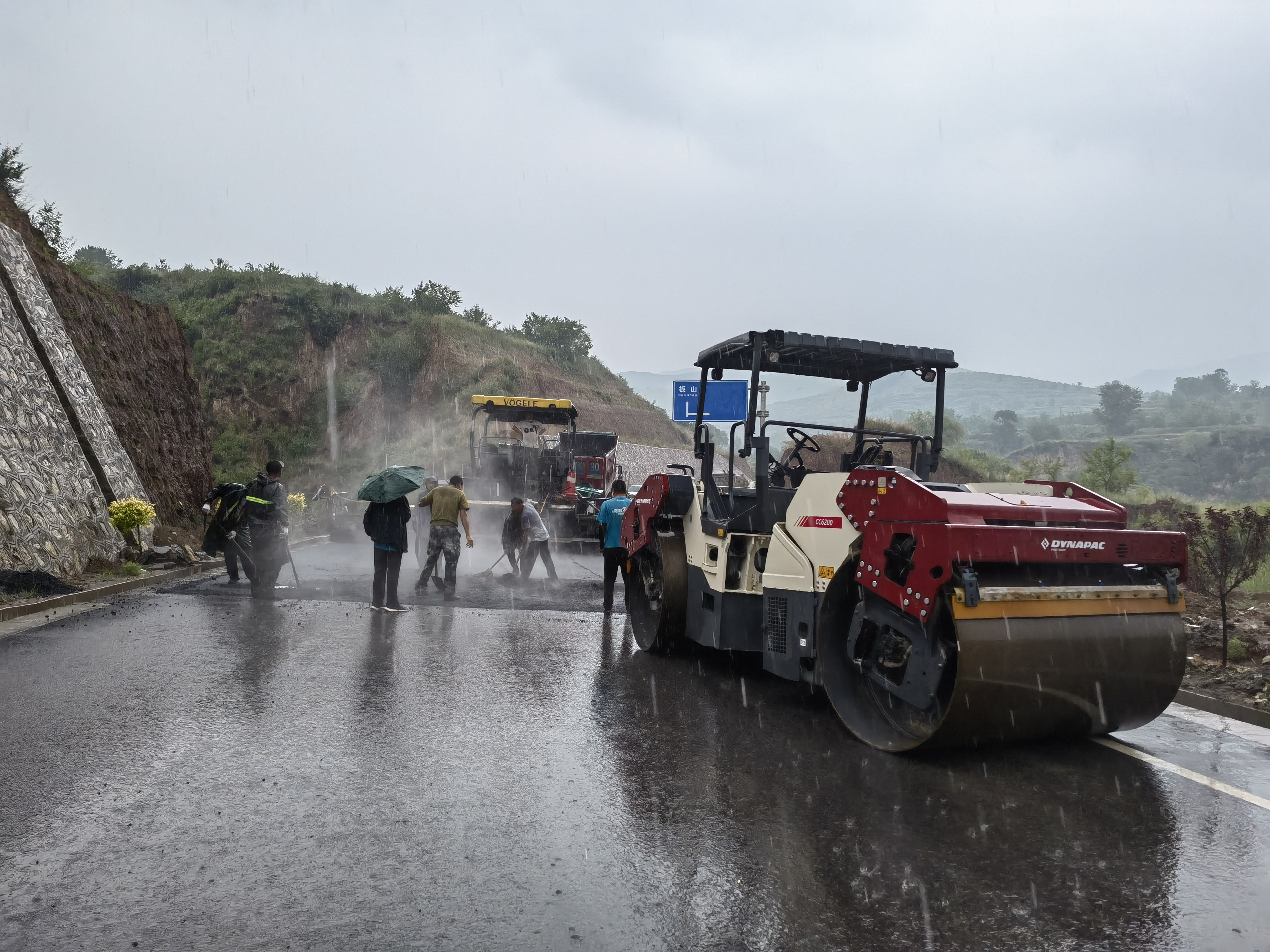 路橋工人在大雨中搶修道路。李華英 攝
