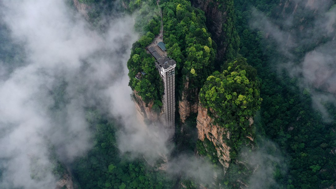 位于張家界武陵源景區(qū)的百龍?zhí)焯蓁偳对谠旗F繚繞的峰林間，雄偉壯觀。吳勇兵攝