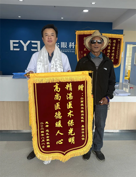 達(dá)瓦老人向吳四華（左）贈(zèng)送錦旗。受訪者供圖