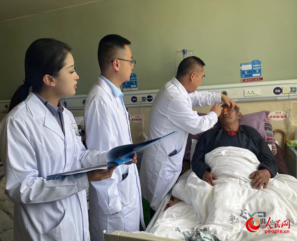 董光明（左三）帶領(lǐng)醫(yī)生對患者進(jìn)行術(shù)前檢查。人民網(wǎng)記者 杜燕飛攝