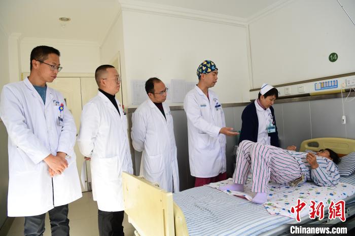 圖為何蔚副主任醫(yī)師(站右二)及團隊術(shù)后指導患者進行腰背肌鍛煉。　貢嘎來松 攝