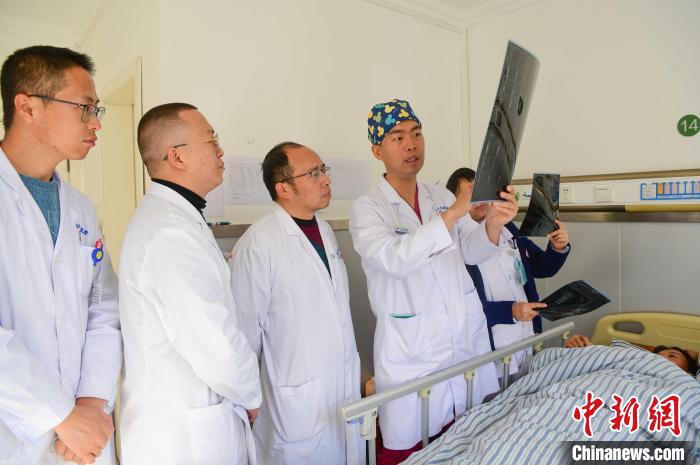 圖為醫(yī)療援藏專家何蔚(站右二)與馮敬云(左二)、廖濤(左三)等人討論患者病情。(資料圖) 貢嘎來(lái)松 攝