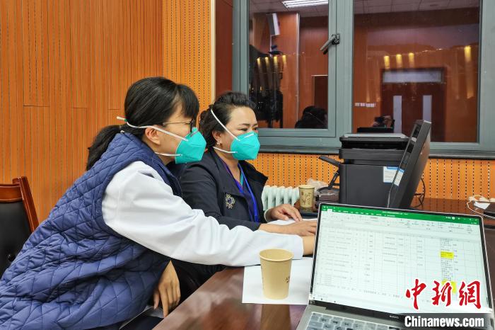 8月9日，楊蘇喬(左)在拉薩方艙醫(yī)院指揮部讀取艙內(nèi)患者胸部CT?！∈茉L(fǎng)者供圖