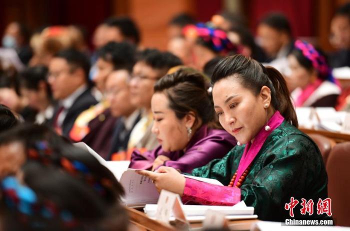 1月5日，次旦卓嘎(右一)在拉薩參加西藏自治區(qū)第十一屆人民代表大會(huì)第五次會(huì)議第二次全體會(huì)議。西藏自治區(qū)人大代表次旦卓嘎來自日喀則市定日縣，定日縣被稱為“洛諧故鄉(xiāng)”，作為西藏民間歌舞，洛諧已被列入中國國家非物質(zhì)文化遺產(chǎn)項(xiàng)目名錄，這是集歌、舞、樂、彈唱于一體的綜合藝術(shù)形式。參加完西藏2022年新年音樂會(huì)的次旦卓嘎告訴記者，每年參加的基層演出可達(dá)80場(chǎng)，“我希望用最純粹的方式，把最好的聲音帶到西藏乃至中國的各個(gè)角落。” <a target='_blank' href='/'><p  align=