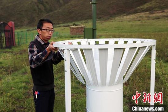 圖為班瑪縣氣象局工作人員在維護藏雪茶基地氣候站。青海省氣象局供圖