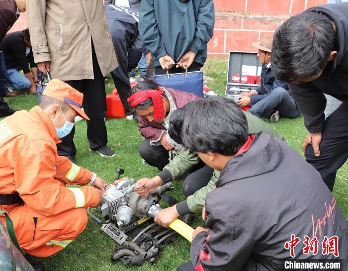 圖為森林消防員為護林員講解滅火裝備的使用方法。　昌都市森林消防支隊 供圖