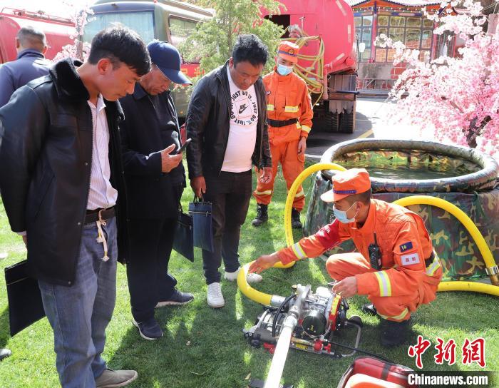 圖為森林消防員為護林員講解滅火裝備的使用方法。　昌都市森林消防支隊 供圖