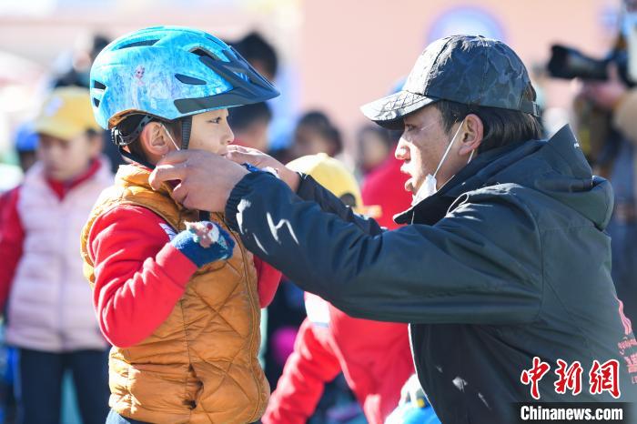圖為拉薩市實驗幼兒園孩子在教練的幫助下穿戴頭盔?！『闻罾?攝