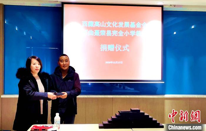 圖為西藏高山文化發(fā)展基金會理事長溫麗向聶榮縣完全小學(xué)負責(zé)人捐助儀器?！∮谫e 攝