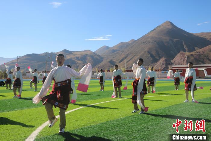 圖為青海師范大學(xué)附屬玉樹實驗學(xué)校學(xué)生在綠茵場跳起囊謙古舞—卓根瑪?！〕逃?攝