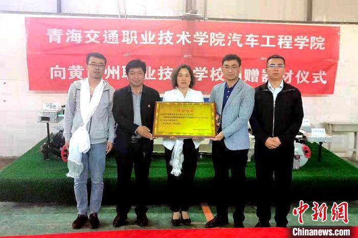圖為李富香(中)代表學(xué)校為州縣技校捐贈(zèng)器材。(資料圖) 青海省教育廳供圖
