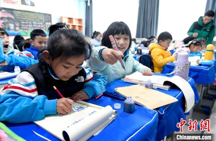 3月14日，西藏拉薩市第一小學(xué)一年級(jí)六班學(xué)生白瑪朗珍(圖左)在藏語文課上書寫藏文。　李林 攝
