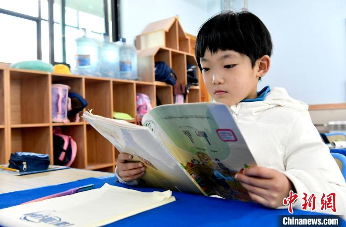 3月14日，西藏拉薩市第一小學(xué)一年級(jí)六班學(xué)生丁增樂吉在閱讀藏語課本?！±盍?攝