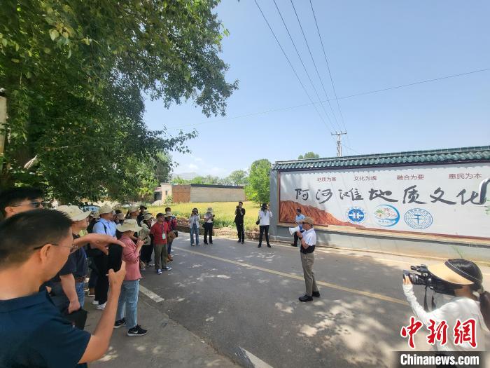 圖為中國(guó)地質(zhì)大學(xué)(北京)教授張緒教介紹村落情況。　胡友軍 攝